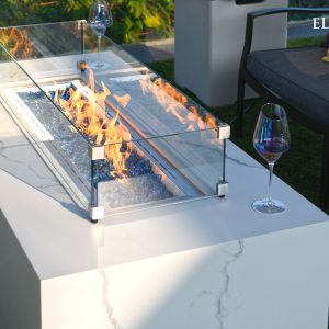 Outdoor fire pit table with flames and a glass of wine on a patio